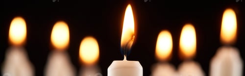 Preview: selective focus of burning white candle glowing isolated on black, panoramic shot