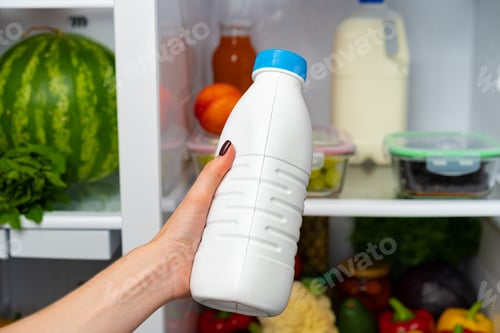 Preview: Female hand taking bottle of milk from a fridge