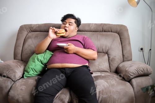 Preview: Overweight Man Enjoying Juicy Burger on Comfy Couch Moment of Pure Indulgence and Relaxation at Home