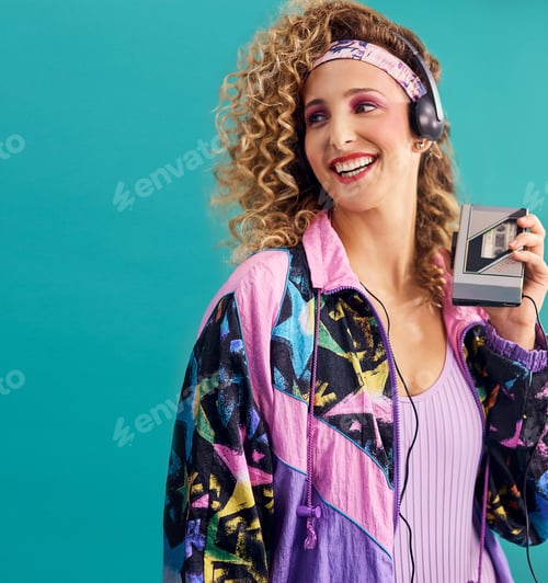 Preview: Studio shot of a young woman holding a cassette player while dressed in 80s clothing