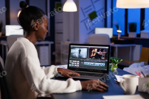 Preview: African american video editor working late at night at digital movie project