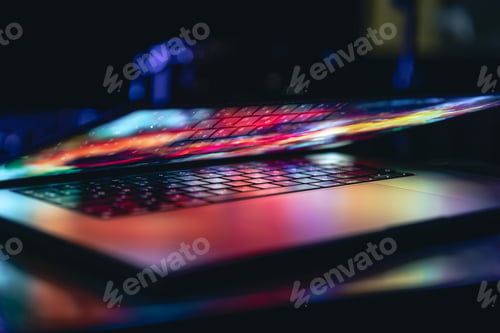 Preview: Close up of laptop keyboard colorful neon illumination, backlit keyboard.