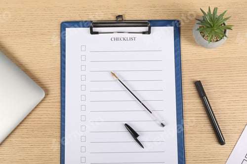 Preview: Checklist with checkboxes, pen, marker, floral decor and laptop on wooden table, flat lay