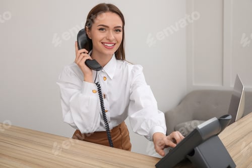Preview: Female receptionist talking on phone at workplace