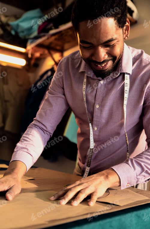 Preview: Male fashion tailor working on the measurements for the suit design in his workshop.