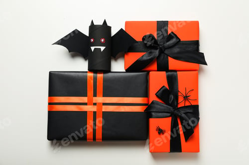 Preview: Gift boxes and paper bats on white background, top view