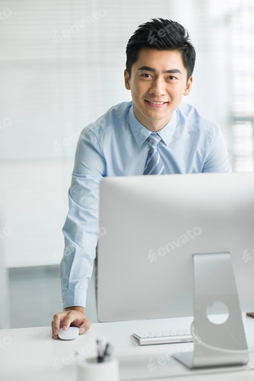 Preview: Young businessman using computer in office