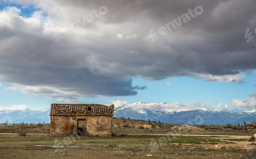 Preview: Wide angle shot of an old house on a mountain under a cloudy sky