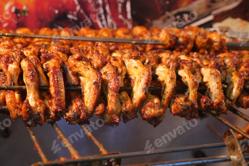 Preview: Chicken skewers grilling at a vibrant street market