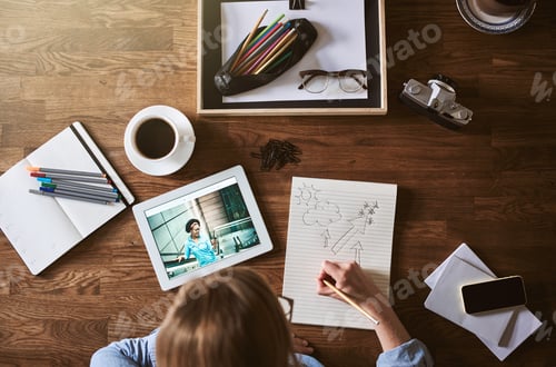 Preview: Designer sketching in a notepad while working from home