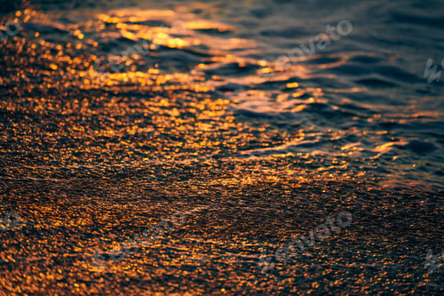 Preview: Sunset light reflection on sea sand surface, beautiful yellow sunlight in sea foam, warm sandy beach