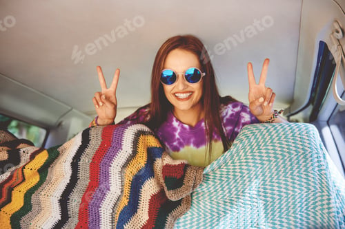 Preview: Portrait of young boho woman making peace sign in recreational van
