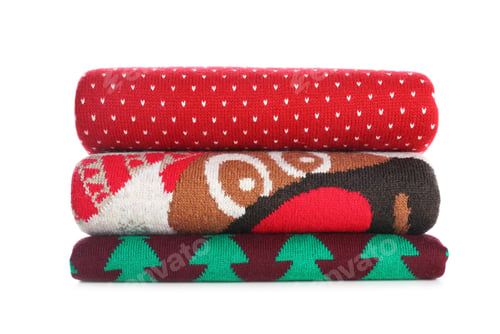 Preview: Stack of warm Christmas sweaters isolated on white