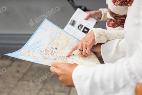 Preview: Mid section of two senior women holding map