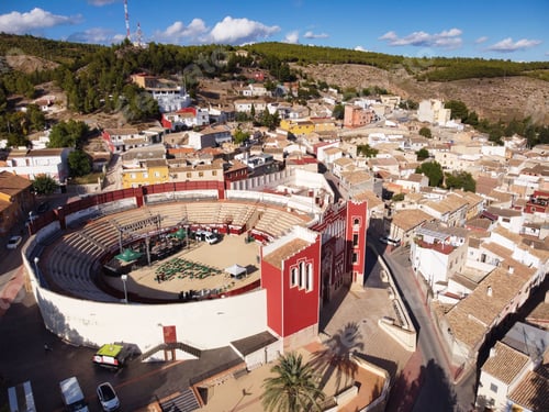 Preview: a large round arena with red and white walls surrounded by buildings