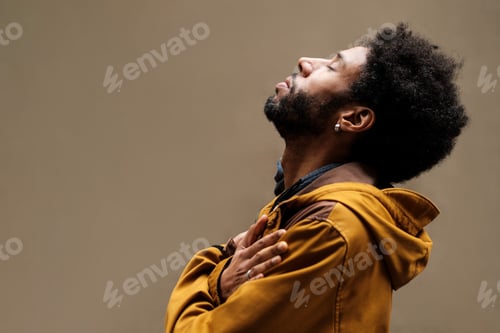 Preview: Young man praying with closed eyes and head up