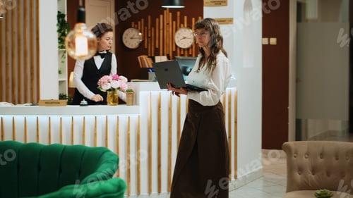 Preview: Senior woman using laptop in lobby