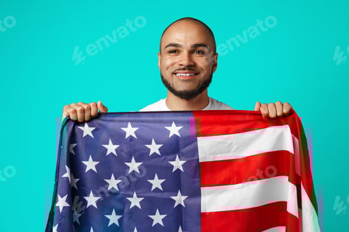 Preview: Portrait of young dark-skinned man proudly holding USA flag