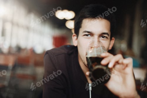 Preview: Man is drinking dark beer
