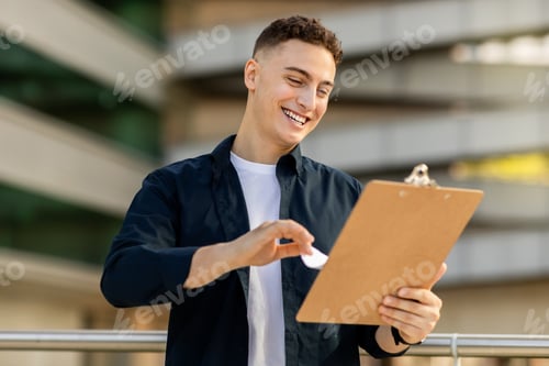 Preview: Glad handsome millennial caucasian man engineer businessman, enjoy work with clipboard