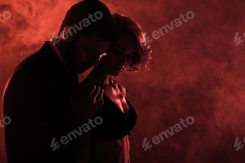 Preview: Man tenderly hugging beautiful woman on red smoke background