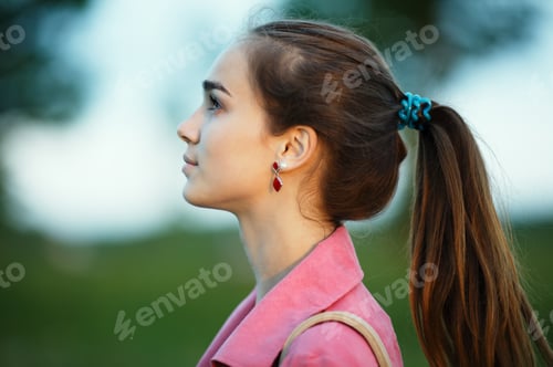 Preview: Contemplative woman in pink jacket looking up