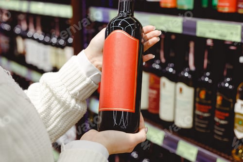 Preview: Woman holding Red wine bottle in supermarket