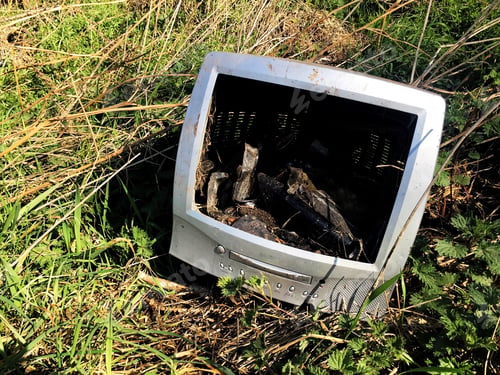 Preview: An old computer monitor or TV that has been dumped on a scrapheap fly tipping on wasteland