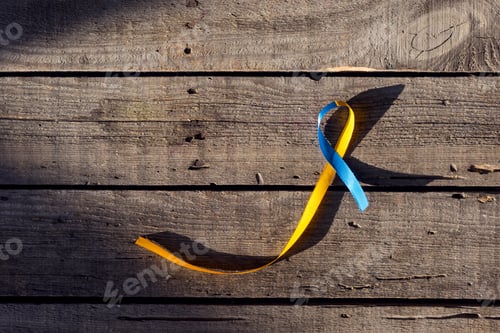 Preview: Blue and yellow ribbon as symbol of Down Syndrome Day on wooden background