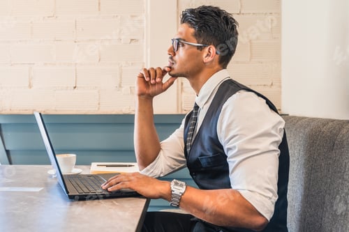 Preview: Man Works on Laptop Computer in Coffee Shop
