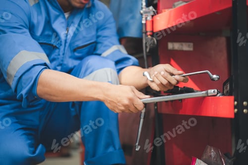 Preview: Professional car mechanics searching for auto repair tools in tool racks, all kinds of auto speciali