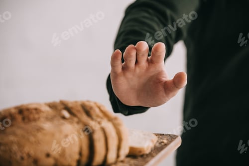 Preview: cropped view of man gesturing near cutting board with sliced bread isolated on grey
