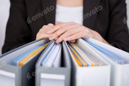 Preview: Midsection Of Businesswoman With Binders At Office