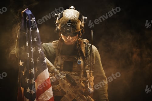 Preview: Special forces soldier holding US national flag in the dark