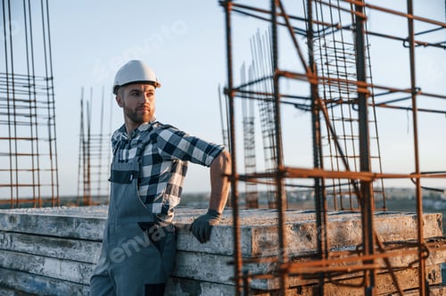 Preview: Standing and taking a break. Man is working on the construction site at daytime