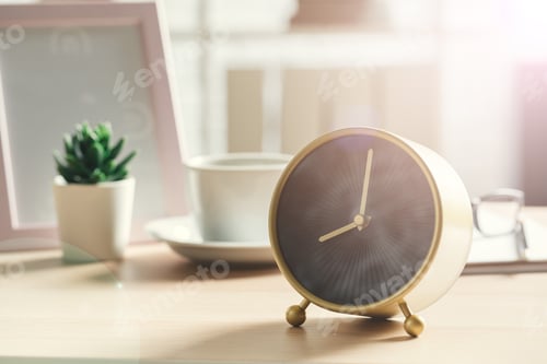 Preview: Old-fashioned alarm clock and house plant on wooden table