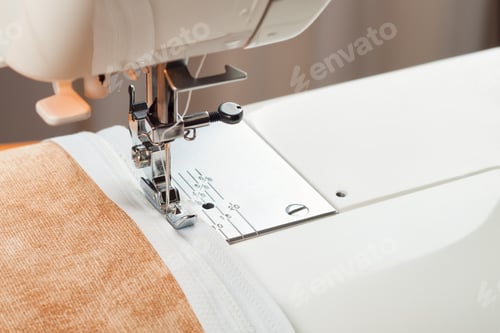 Preview: Modern sewing machine sews on the zipper on beige item of clothing. sewing process