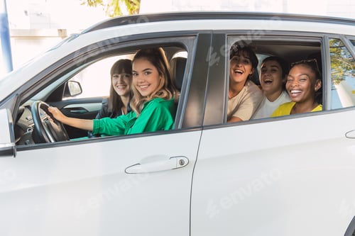 Visualização: Amigos alegres sentados em um carro branco estacionado à luz do dia perto do prédio