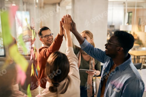 Preview: Happy multiracial start-up team uniting their hands in the office.