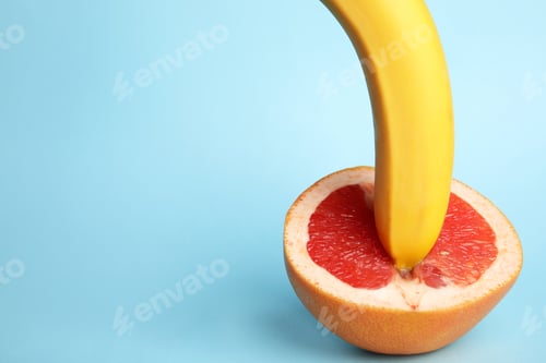 Preview: Fresh grapefruit and banana on blue background, space for text. Sex concept