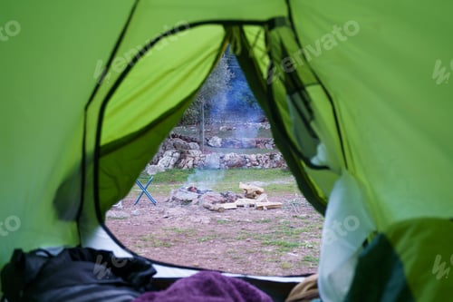 Preview: Views of a campfire from inside a tent. Camping Concept
