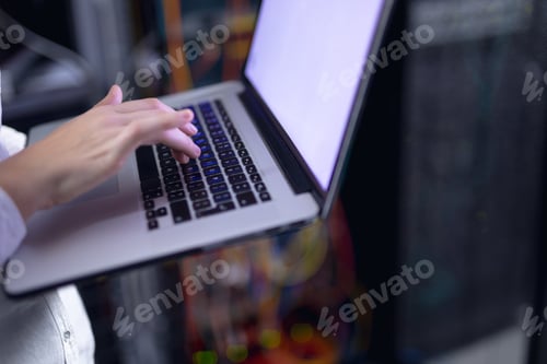 Preview: Mid section of woman laptop in computer server room