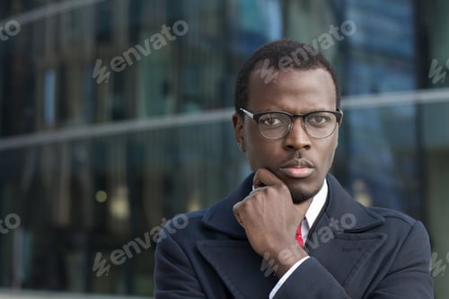 Preview: Thoughtful Businessman Posing in Front of Office Building