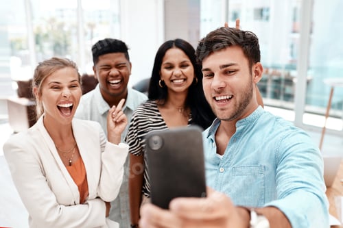 Group Smiling Together Taking Selfie in Office Setting