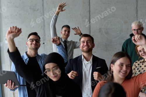 Preview: A diverse team of business professionals ecstatically celebrating their success in a modern office