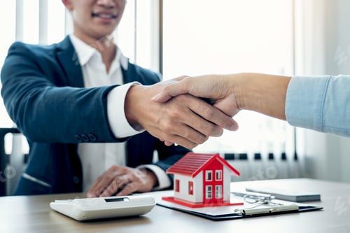 Preview: Estate agent and customers shake hands together celebrating the