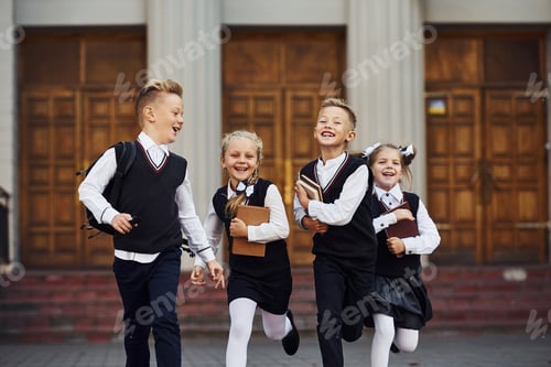 Preview: Group of kids in school uniform that is running outdoors together