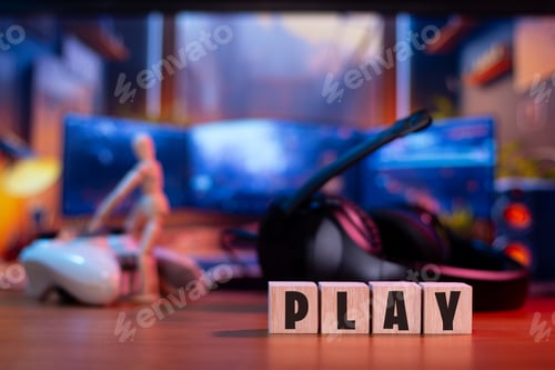 Preview: Wooden cubes forming the word play on the table of a modern gamer setup