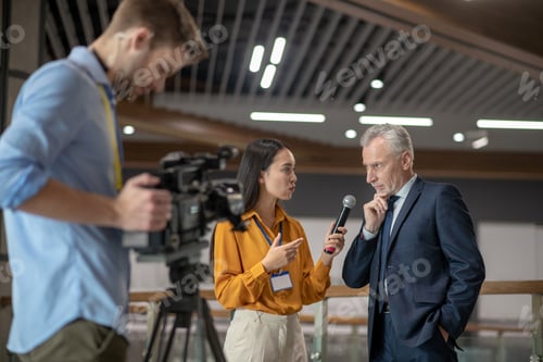 Preview: Young female reporter having interview with famous businessman