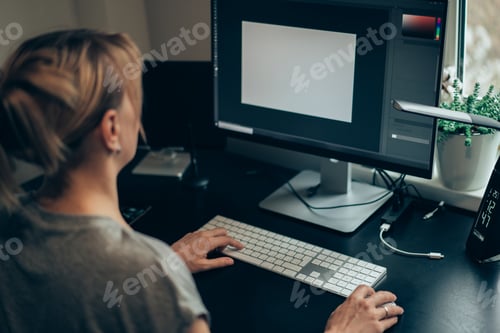 Preview: Female works with tables on her personal computer with big display. Woman works at home
